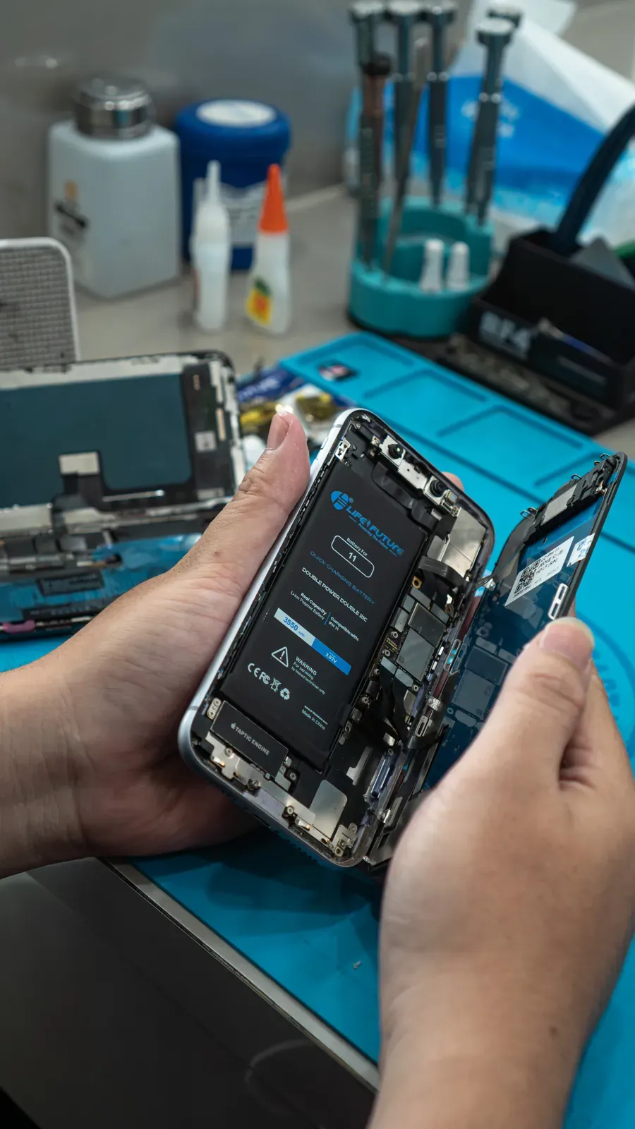 Teknisi Raja Repair membongkar dan memperbaiki smartphone
