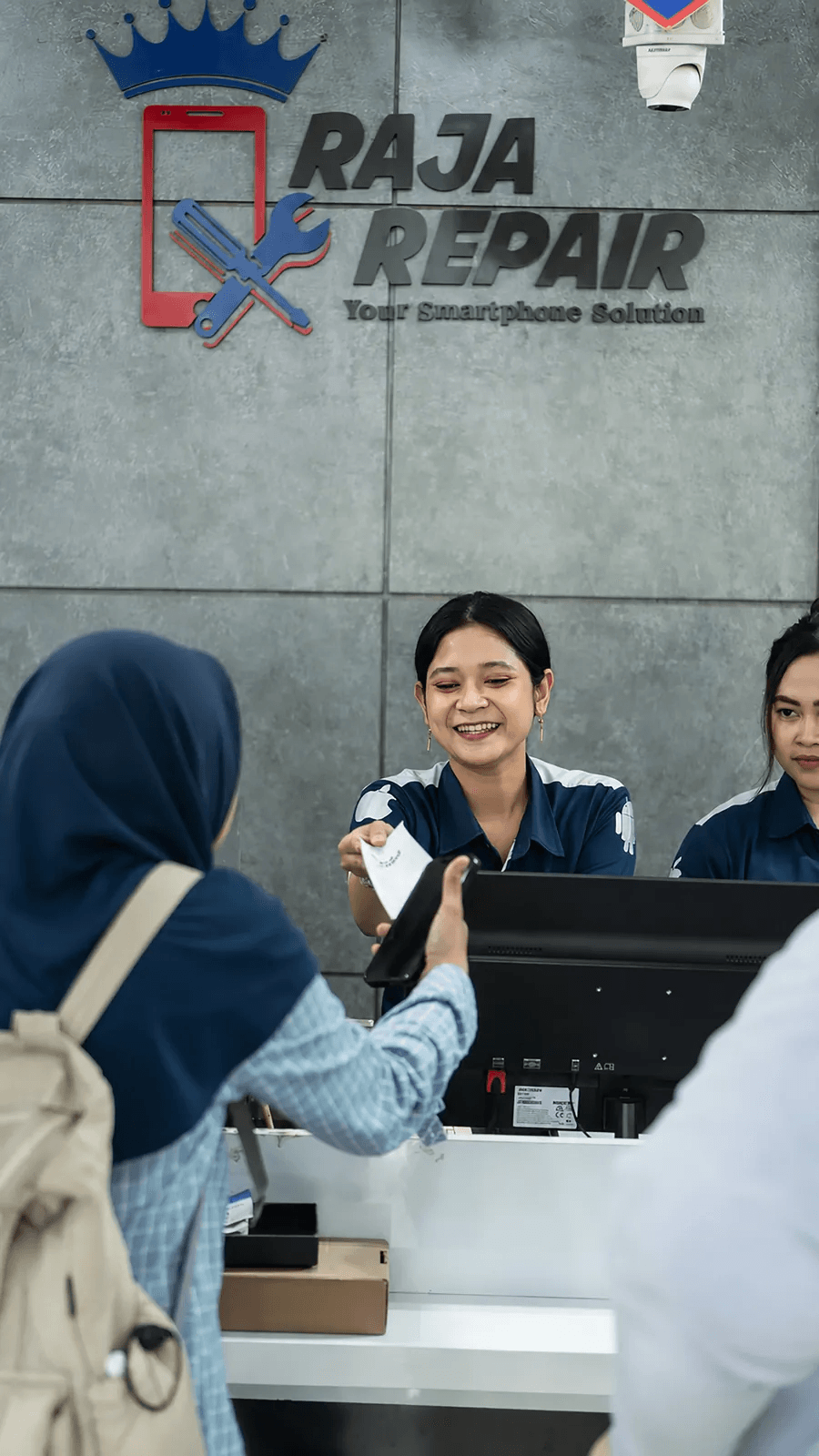 Staf Raja Repair melayani pelanggan di meja depan